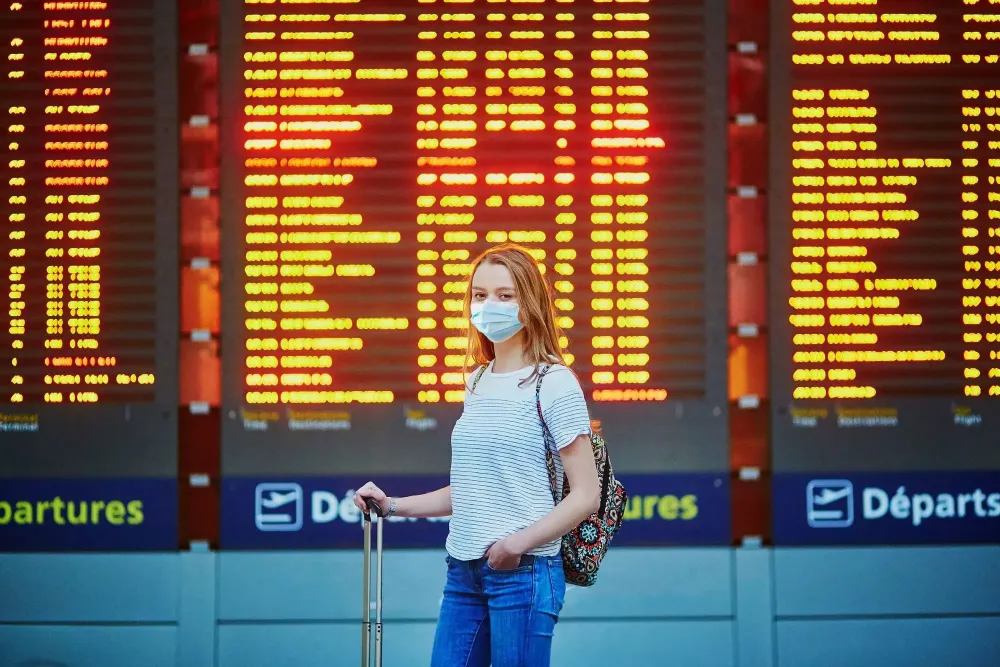 woman at airport wearing mask.